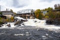 Small dam along a river on a cloudy autumn day