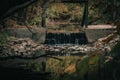 Small dam over the river against the fall forest background Royalty Free Stock Photo