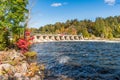 Small Dam on a river under blue sky in fall Royalty Free Stock Photo