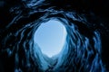 Small dark ice cave tunnel on the Matanuska Glacier in Alaska. The cave is dark but light shines on the clear ice inside Royalty Free Stock Photo