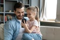 Small daughter showing to father new cool game on smartphone