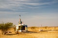 Small decorated hindu temple in the middle of desert with cloudy blue sky Royalty Free Stock Photo