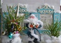 Small decorated New Year tree with Father Frost and old house in the background