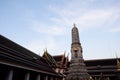 A small, decorated tower stands in the courtyard of Wat Pho Monastery in the evening