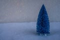 Small decorative blue Christmas tree with artificial snow on light blue background Royalty Free Stock Photo