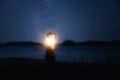 Small decorative lighthouse luminous in the dark. Lighthouse under the Milky Way