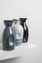 Small decorative porcelain vases of blue, white and black colors on a white wooden shelf Royalty Free Stock Photo