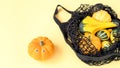 A small decorative pumpkins in a black color string shopping bag Royalty Free Stock Photo