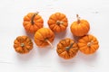 Small decorative pumpkins on white wooden background. Autumn, fall, thanksgiving or halloween day concept, flat lay, top view Royalty Free Stock Photo