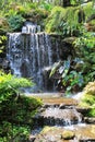Small decorative waterfall in the public garden Royalty Free Stock Photo