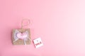 Small decorative wicker handbag and white paper card with words SALE on pink background. Valentine`s day sale concept