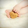 Small delicate little feet to keep the wooden heart Royalty Free Stock Photo