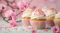 small delicious Easter cupcake and some sprinkles with pink blossoms, soft light background, banner Royalty Free Stock Photo