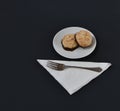 Small Desert plate of Two Bite sized Coconut Macaroons with fork and black background.
