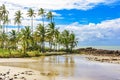 Small deserted beach hidden between rocks and coconut trees Royalty Free Stock Photo