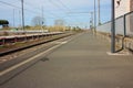 A small deserted local station during the day. sidewalk for waiting passengers waiting for trains for their journeys, between