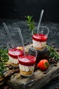 Small dessert: strawberries, cream and nuts in plastic cups. Royalty Free Stock Photo