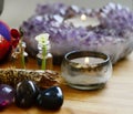 Small detailed flowers, tea light candle and amethyst candle holder. Occult themed, witchy alter in moody lighting. Macro lens Royalty Free Stock Photo