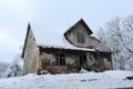Small dilapidated abandoned house covered with fresh snow