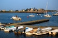 Small dinghies line a pier in a calm harbor Royalty Free Stock Photo