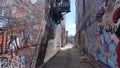 Small and dirty alley with lots of graffiti at Kensington market in Toronto - TORONTO, ONTARIO - APRIL 15, 2024 Royalty Free Stock Photo