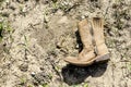 Small dirty western cowboy boot on dry ground