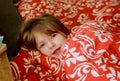 A small diseased girl in the bedroom. Little girl sitting on a bed wearing a pajamas. Royalty Free Stock Photo