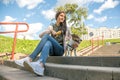 dog and her owner teenager girl are sitting on steps of stairs Royalty Free Stock Photo