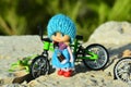 Small doll in a blue clothes and bicycle