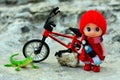 Small doll in a red clothes and bicycle