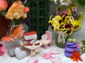 Small dollhouse chair, table with tiny books among beautiful flowers of daisy and begonia. Fairies in the garden