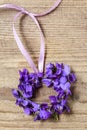 Small door wreath with tiny violets viola odorata flowers on wood