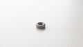 A small doughnut shaped gray object resting on a smooth white surface Royalty Free Stock Photo