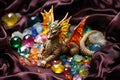 a small dragon figurine lying amongst colorful gemstones