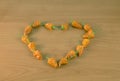 Small dried chilli peppers on wooden table heart Royalty Free Stock Photo