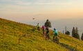 Small drone flies along a group of tourists mountain biking on a sunny evening. Royalty Free Stock Photo