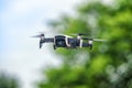 Small drone in flight against defocused foliage