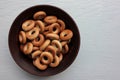 Small dry bagels for kids in brown ceramic bowl on white wooden background. Healthy snack Royalty Free Stock Photo