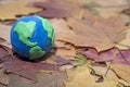 Small Earth model on autumn leaves Abstract composition of peace Royalty Free Stock Photo