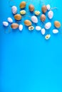 Small easter eggs different size on blue background with copy space. Royalty Free Stock Photo