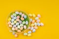 small Easter eggs lie in a basket on a yellow background Royalty Free Stock Photo