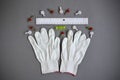 Small elements for wall mounting, white gloves, plastic ruler and level are placed on gray background. Accessories, tools