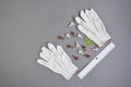 Small elements for wall mounting, white gloves, plastic ruler and level are placed on gray background. Accessories, tools