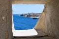 Valletta, Malta, August 2019. View through the embrasure in the wall of the bay and the old fort. Royalty Free Stock Photo