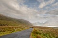 Small empty road leads into mountains. Low cloudy sky, Connemara, Ireland. Nobody. Travel concept Royalty Free Stock Photo