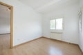 Small empty room with oak laminate flooring with matching skirting boards and doors, aluminum double pane window with shutter and Royalty Free Stock Photo