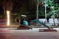 Small excavator on Beach Road at night.