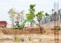 Green excavator digging pond in factory for make garden Royalty Free Stock Photo