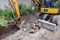 Small excavator is excavating soil at construction site, project