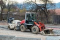 Small excavator and road roller at street construction site.